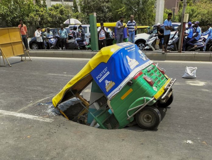 Auto rickshaw plunges into caved-in portion of road