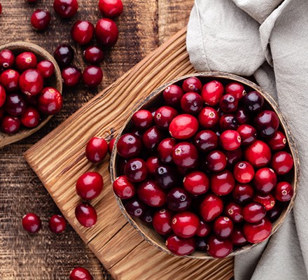 Red cranberries on wooden background. Brries in a bowl.