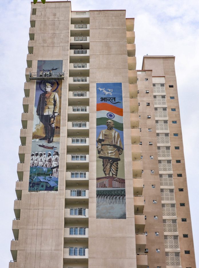Standalone: Workers install mural on a high rise facade in Delhi