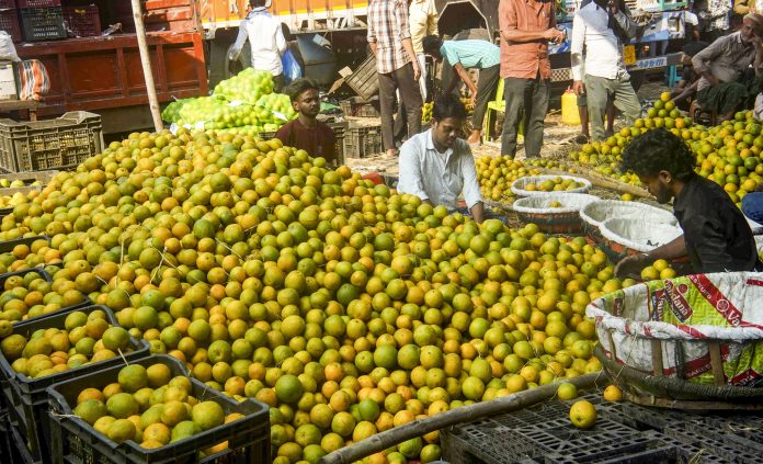 Vendors sort oranges at a market in Kolkata